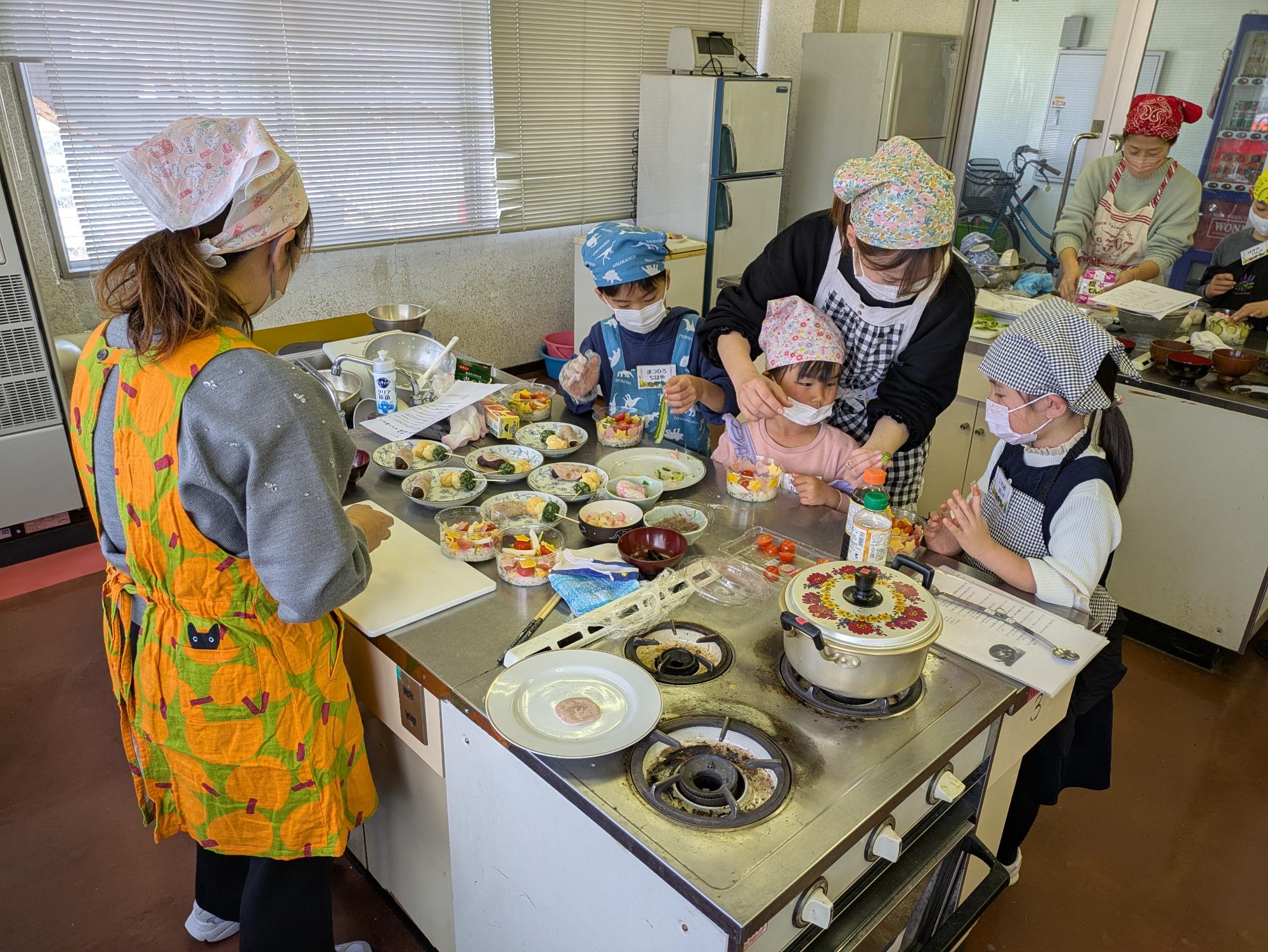 家族でひなまつり男の子も女の子も上手にカップにちらし寿司を盛りつけている写真