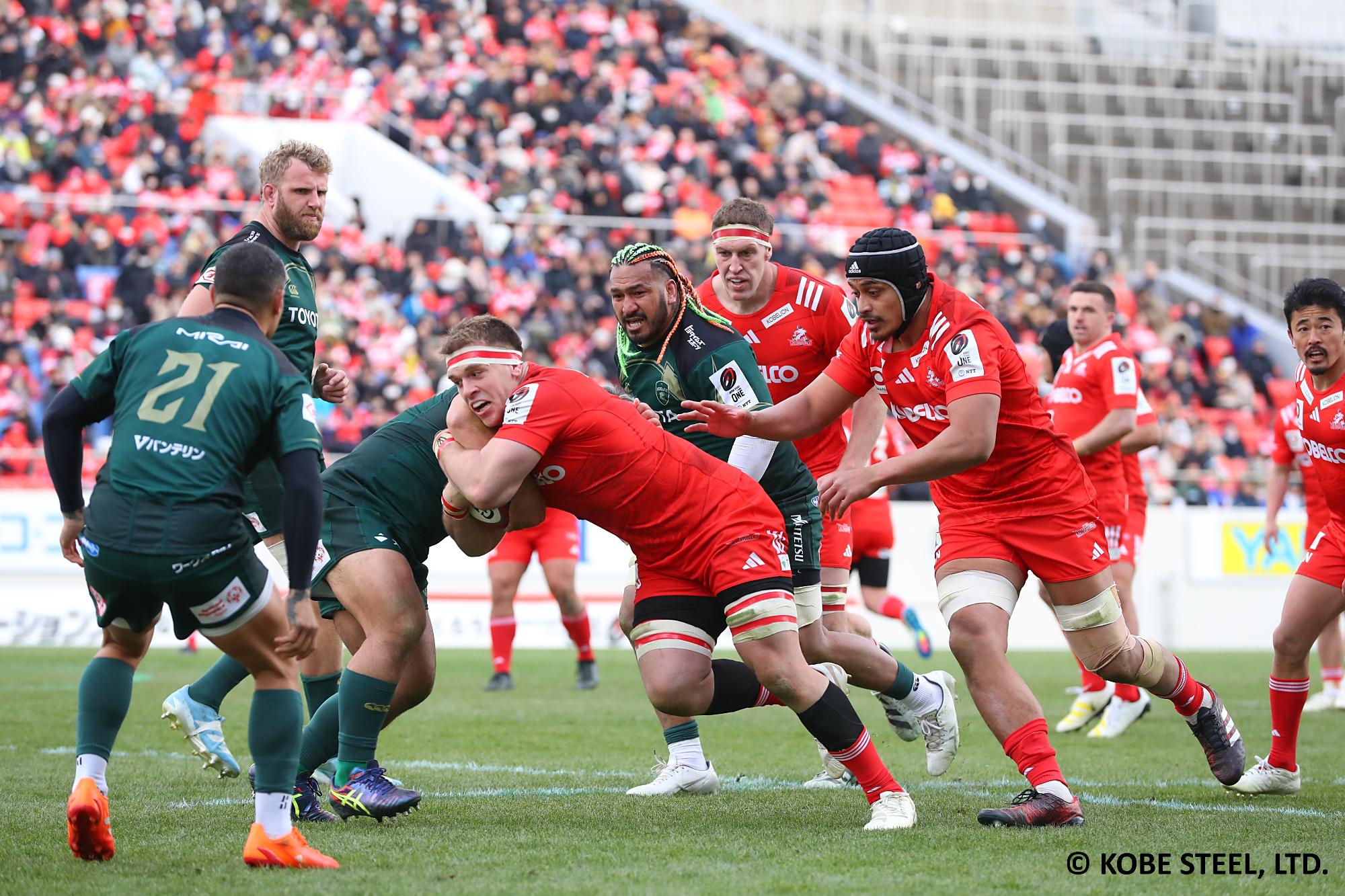 ラグビーボールを抱えた選手とそれを止めようとしている選手が取っ組みあっている写真