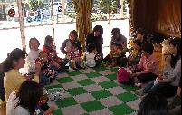たくさんのお母さんとひざに抱えられたお子さんとが円状に集まって親子教室を楽しんでいる写真