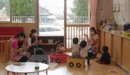 車型の椅子に座りながら手遊びを楽しむ子供たちの写真