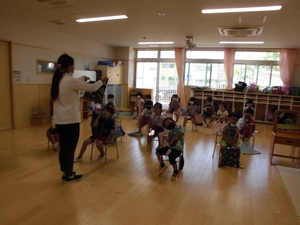 椅子に座りながら先生の打ち合わせ内容を聞く子供たちの写真