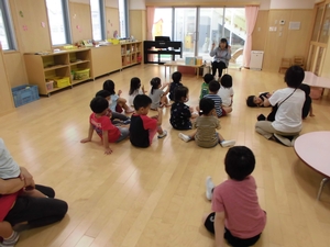 先生の読み聞かせを座って聞くひまわり組の子供たちの写真