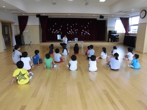 先生の読み聞かせを座って聞くゆり組の子供たちの写真
