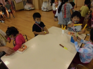 さっきお店屋さんで買ったおもちゃの商品を並べて笑うお客様役の子供たちの写真