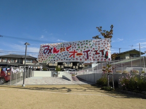 「みんなでオーイエイ!」と書かれた手作りの横断幕の写真