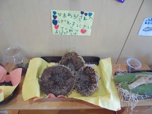 棚に置かれたヒマワリの花の種の部分と、「ひまわりさんへ げんきにさいてくれてありがとう」と書かれたお手紙の写真
