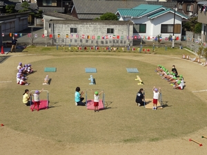小型の鉄棒の前に立つ子供たちの写真