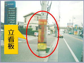 電柱の前に立てかけられている立看板を示した写真