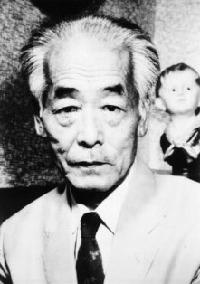 ネクタイをして正面を向いている白髪の佐々木すぐる氏のモノクロ写真