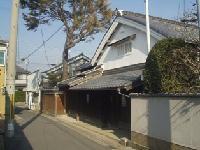 住宅街に建つ白い蔵造りの建造物の写真