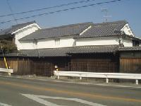 道路沿いに建つ白い蔵造りの建造物の写真