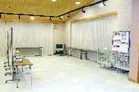 白い部屋に展示パネルと長机が並んでいる写真