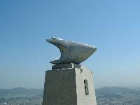 青空の下建つグライダーの石像の写真