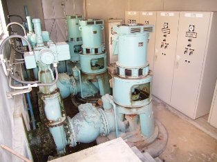 建物内に薄緑色のポンプ設備が並んでいる写真