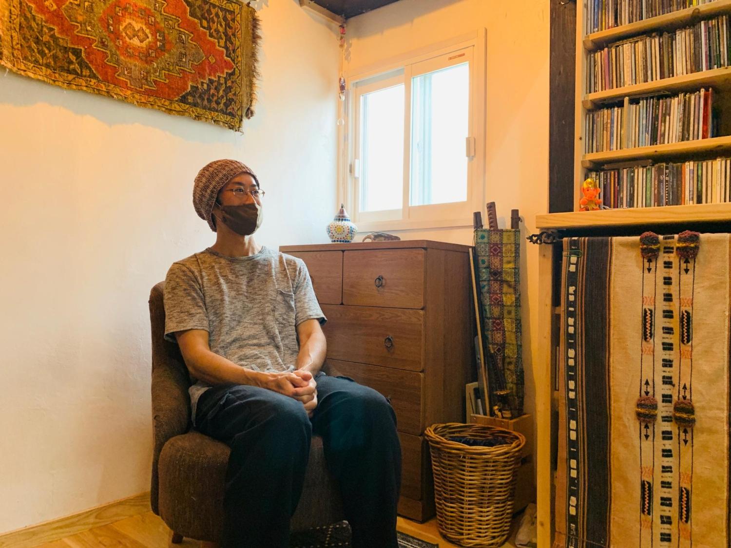アジアンテイストのおしゃれな部屋でソファーに座る帽子をかぶった男性