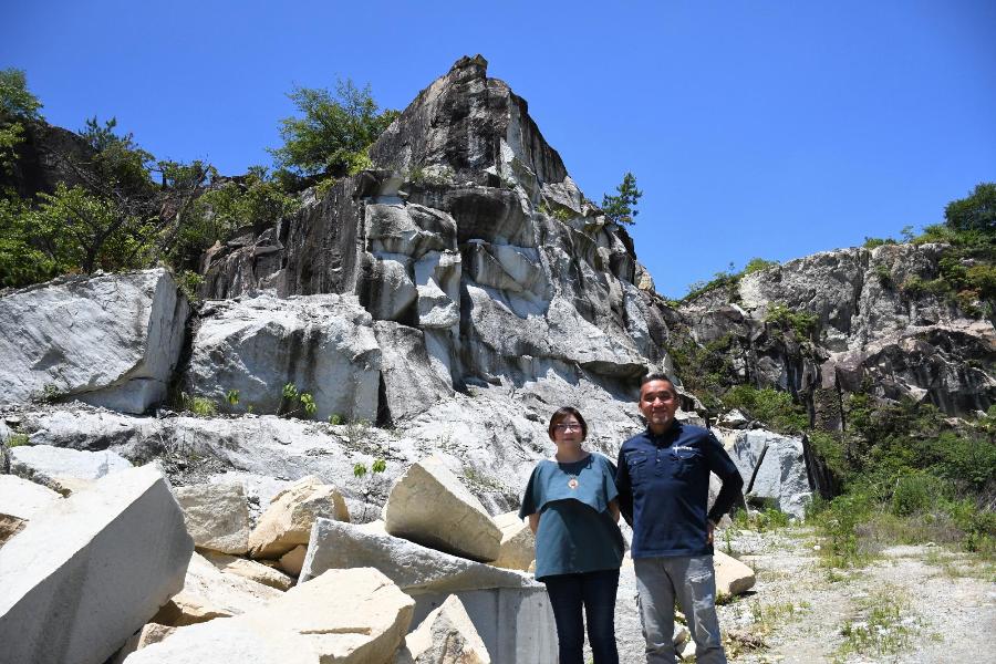 竜山石の採石場の前に立つ男女の写真