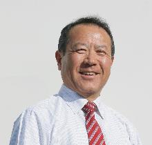 スーツ姿で正面を向いている笑顔の横田英樹議員の写真