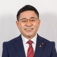 スーツ姿で正面を向いている笑顔の石崎徹議員の写真