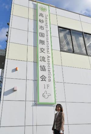 高砂市国際交流協会の建物の前に立つ女性の写真