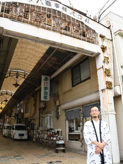 銀座商店街の入り口に立つ法被姿の男性の写真