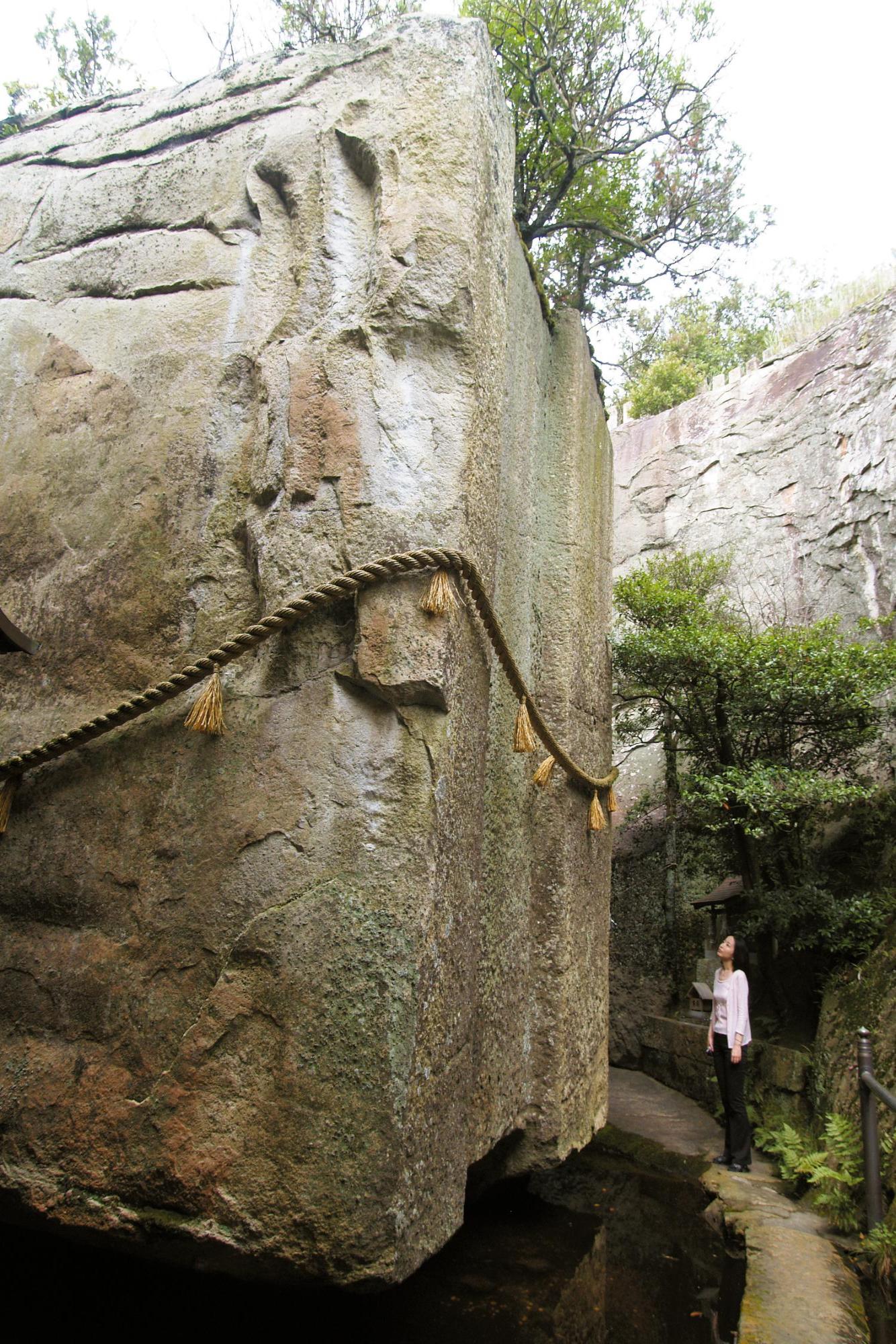 生石神社の石の宝殿を見上げる女性