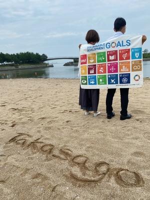 砂浜に「Takasago」と書かれた向島の砂浜で撮られたSDGs活動を啓蒙する写真