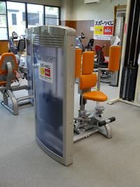 トレーニング場に置かれたフライというオレンジ色の直立した座席で作られたトレーニング機器に「スポーツくじtoto」のロゴが貼られている写真