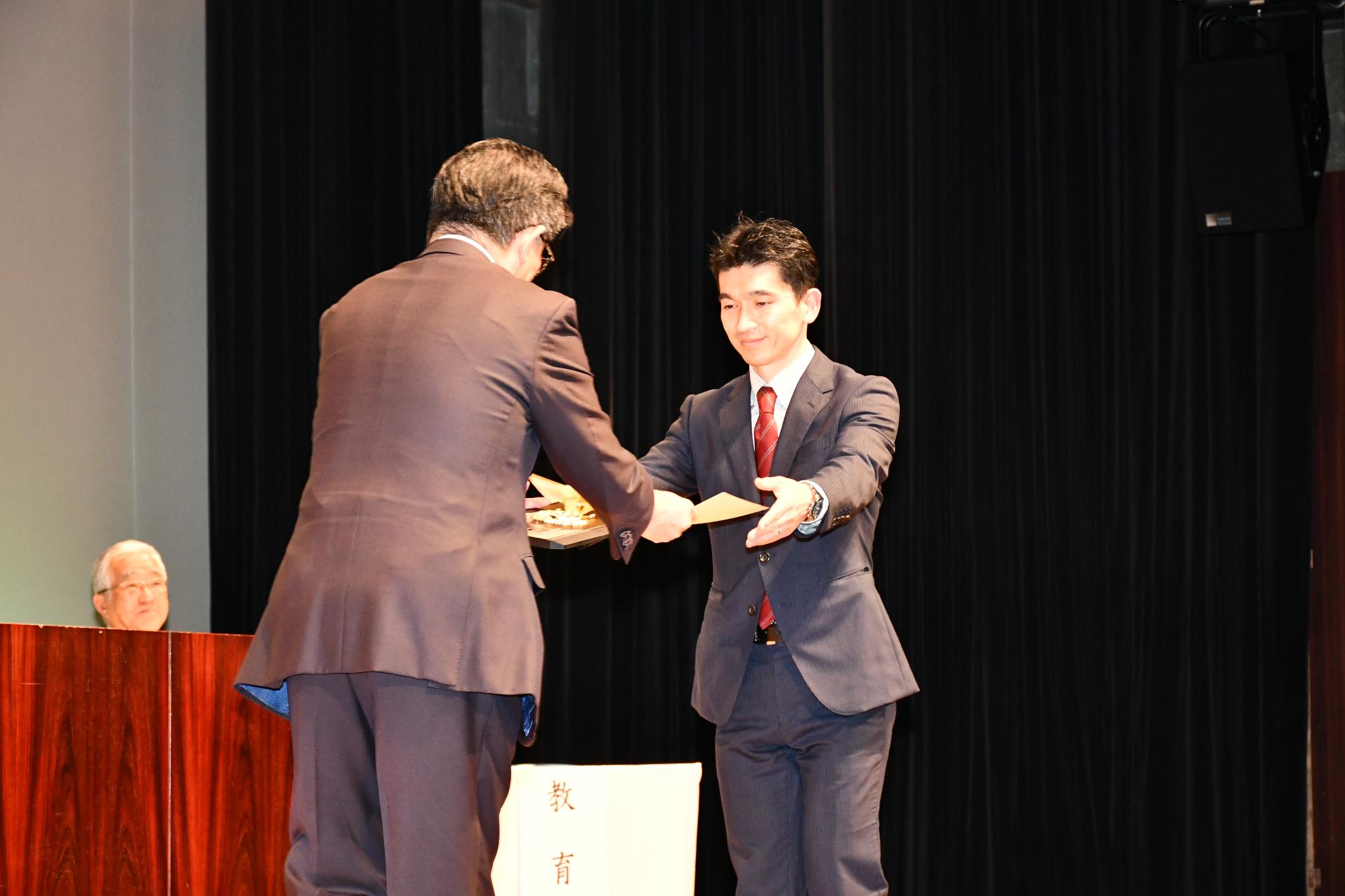 特別優秀選手賞の受賞者に市長が表彰状を渡している画像