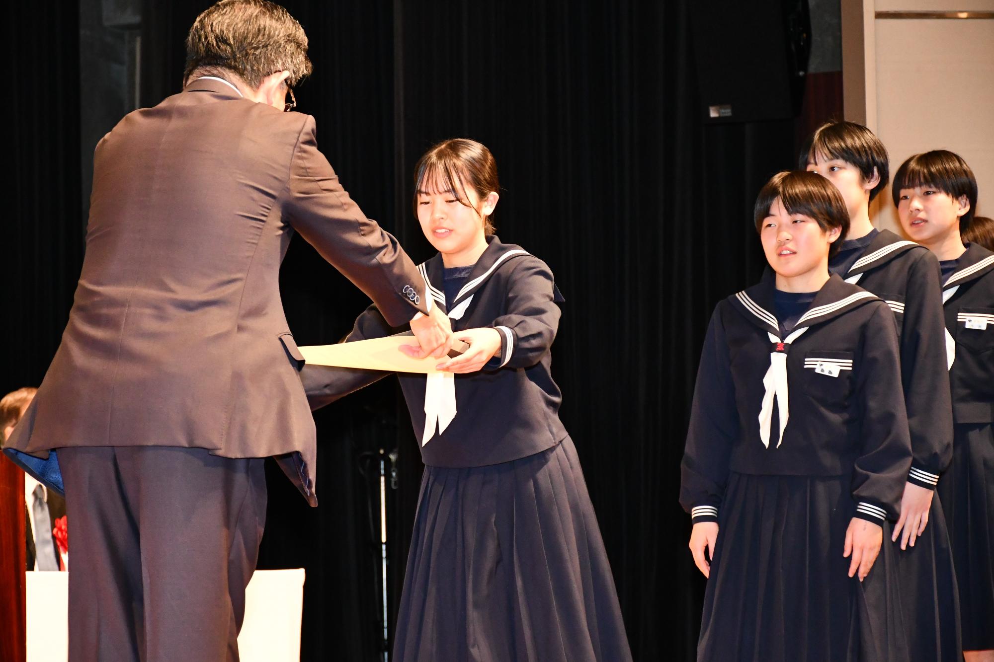 優秀団体賞の受賞者に市長が表彰状を渡している画像