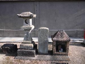 文字が刻まれた灯籠と石碑と石の祠が並んでいる写真
