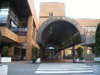 茶色く大きな外装で建物の入り口がアーチ状の屋根に覆われている文化保健センターの写真