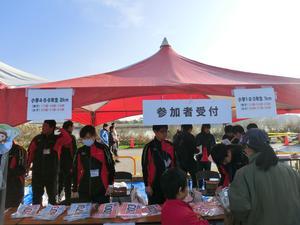 参加者受付と書かれた赤いテントの下で手続きするスポーツ推進委員の写真
