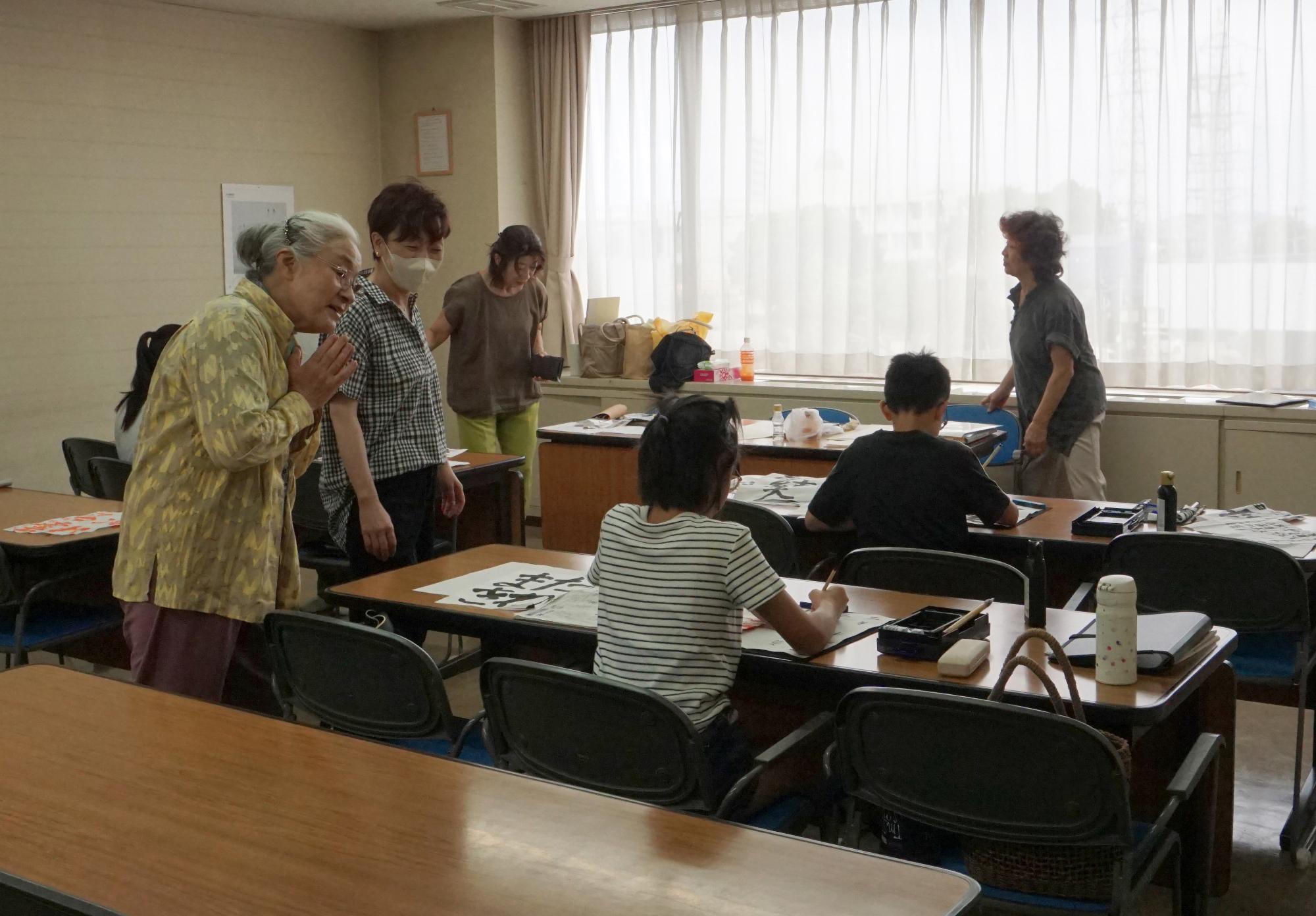 子供たちが先生から書道を習っている様子