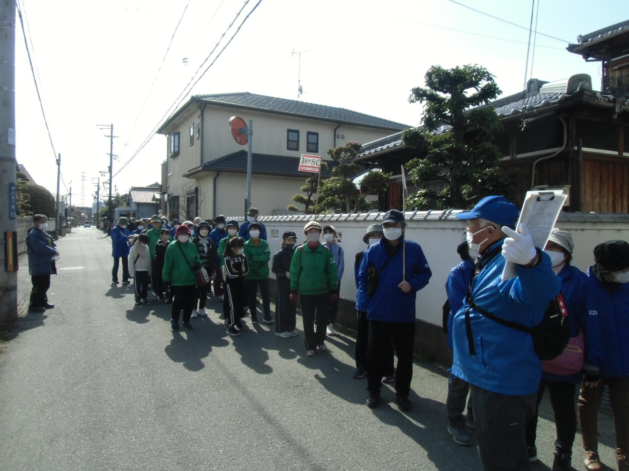 高砂歴史ガイドクラブの人たちの解説を聞きながら歩いている写真