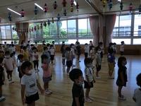 園内の体育館でおこなわれた終業式でマスクをしながら等間隔に整列する園児たちの写真