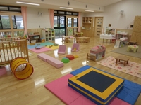 黒い屋根が特徴的な曽根こども園の南棟外観をやや遠目のアングルから撮影した写真