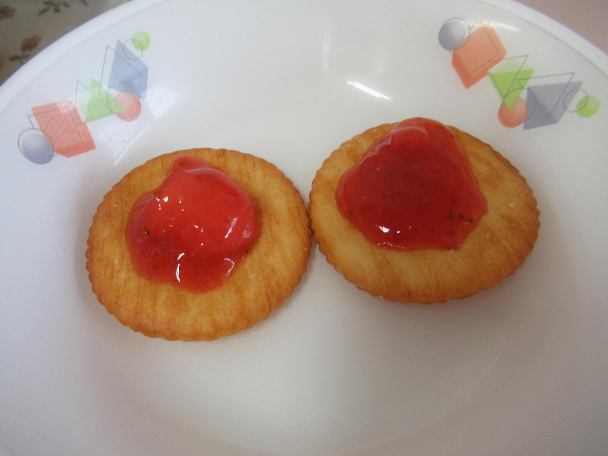 クラッカーの上にいちごジャムが乗っている写真