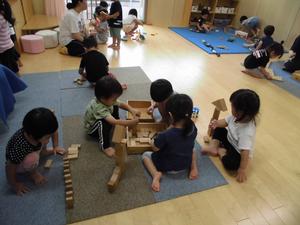 積み木を並べたり、建物を作ったりして思い思いに遊ぶ子供たちの写真