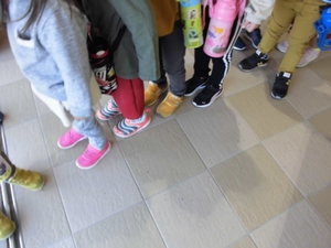 靴を履いて玄関前で整列する子供たちの写真