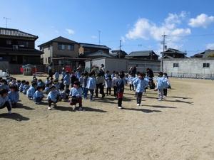 青空の下グラウンドに集まる園児たちの写真