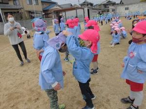 ひよこ組の園児たちが進級生たちにペンダントをかけている写真