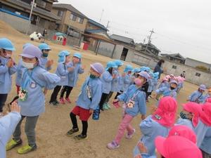 在園児たちに拍手をされて見送られる進級生たちの写真