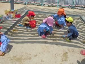 数名の園児たちが砂場で遊んでいる写真