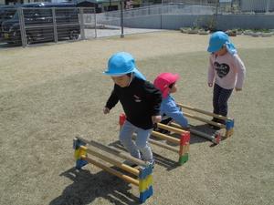 子供用の小さなハードルを三段に積んでいる園児たちの写真