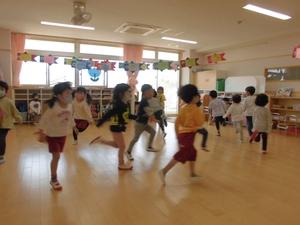 室内で園児たちが後ろけり足をしている写真