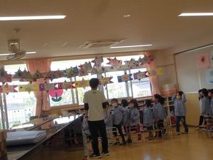 別のクラスの作った手作りこいのぼりの飾りを眺める子供たちの写真