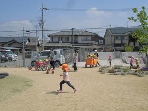 青空の下校庭で走る子供の写真