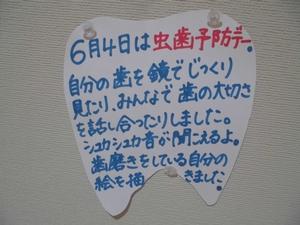 壁に画鋲で留められた、虫歯予防デーについて書かれた歯の形を模した張紙の写真