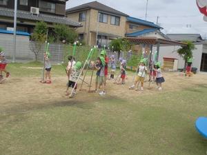 芝生の上で竹馬に乗る子供たちの写真