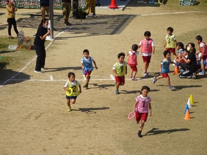 ゼッケンを着てグラウンドを走る子供たちの写真